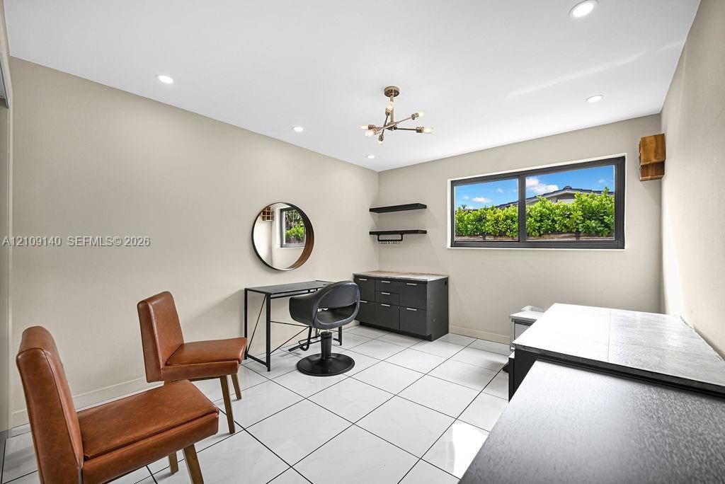 Bright room featuring large-format tile flooring, recessed lighting, a multi-arm modern light fixture, and horizontal picture windows