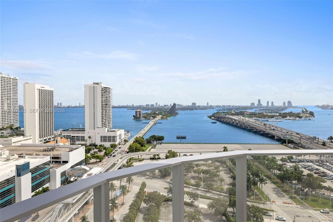 Elevated balcony featuring a glass railing with a panoramic outlook of the surrounding bay, bridges, and metropolitan skyline