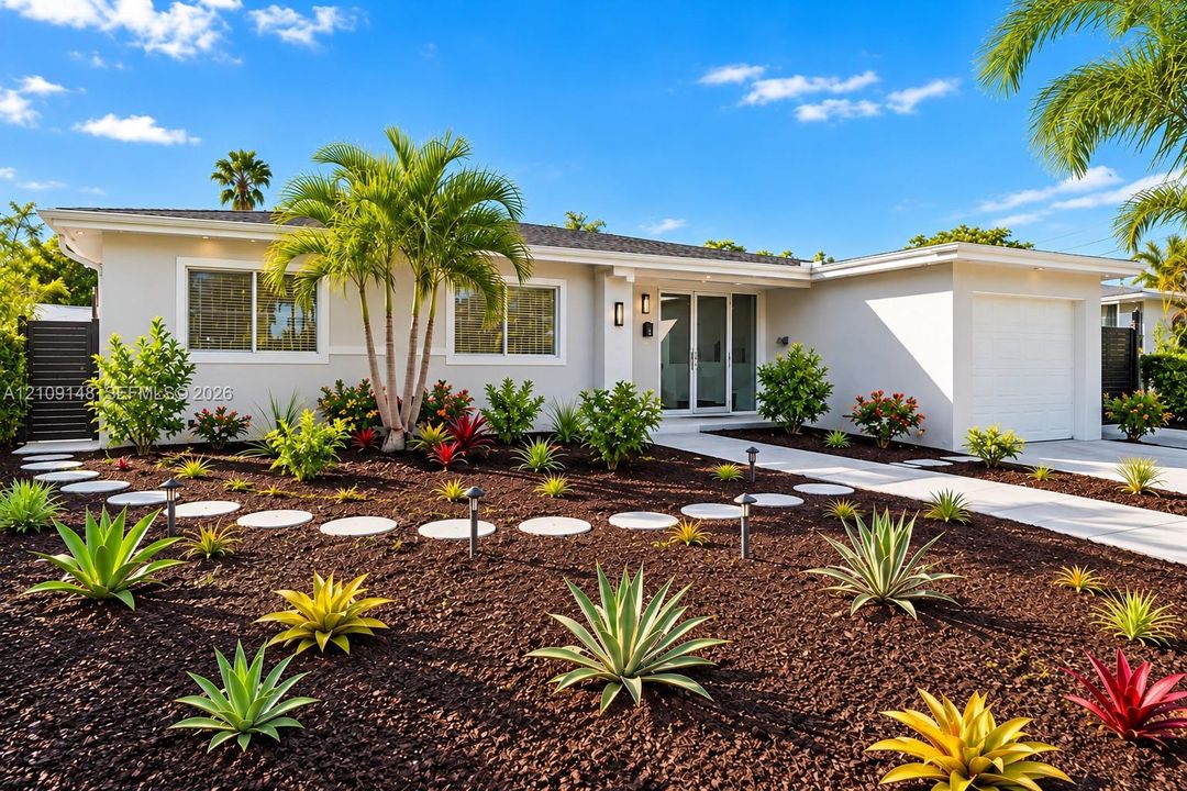 Single-story exterior featuring light-toned smooth stucco, a concrete paver walkway, professional xeric landscaping, mature palm trees, and an attached garage