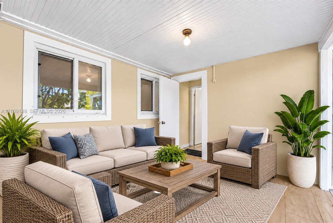 Covered porch featuring wood-finish flooring, beadboard ceiling, and dual-pane windows