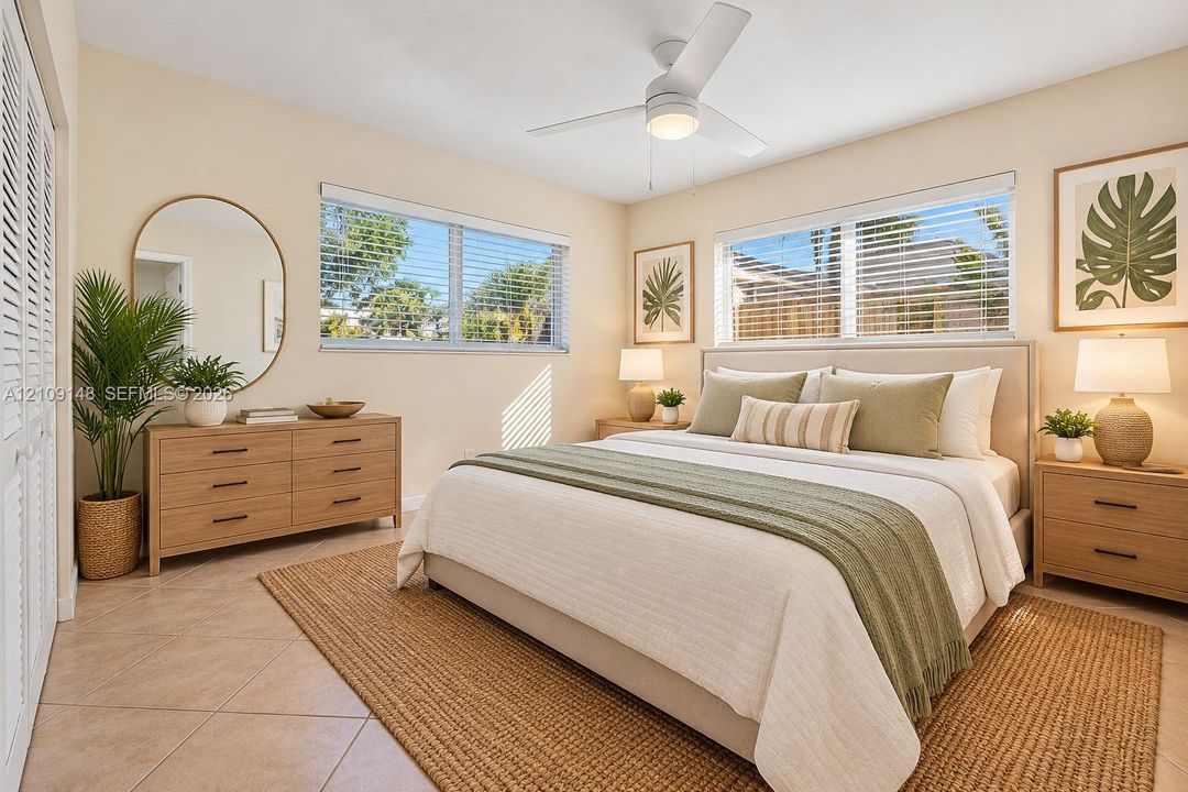Neutral-toned interior featuring tile flooring, dual-pane windows, louvered closet doors, and a ceiling fan with integrated lighting