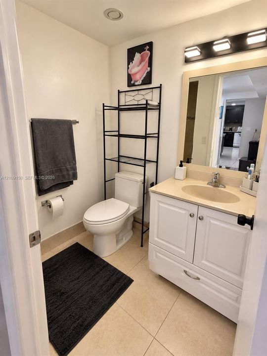 Vanity featuring a solid surface countertop, white shaker-style cabinetry, and an integrated oval sink