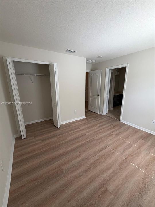 Wood-finish flooring, neutral wall tones, bi-fold closet doors, and multi-panel interior doors