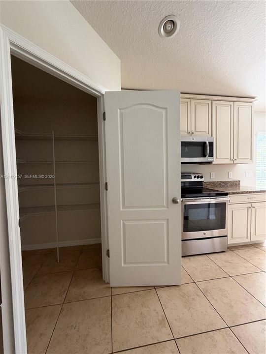 Vaulted ceilings, wood-finish flooring, kitchen featuring a peninsula island, tile flooring, and sliding glass door