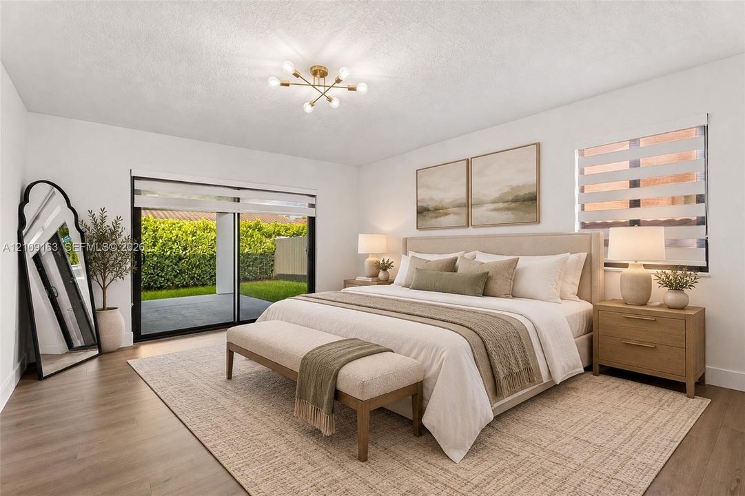 Neutral-toned room featuring wood-finish flooring, sliding glass door with external access, multi-light modern ceiling fixture, and dual windows equipped with horizontal blinds