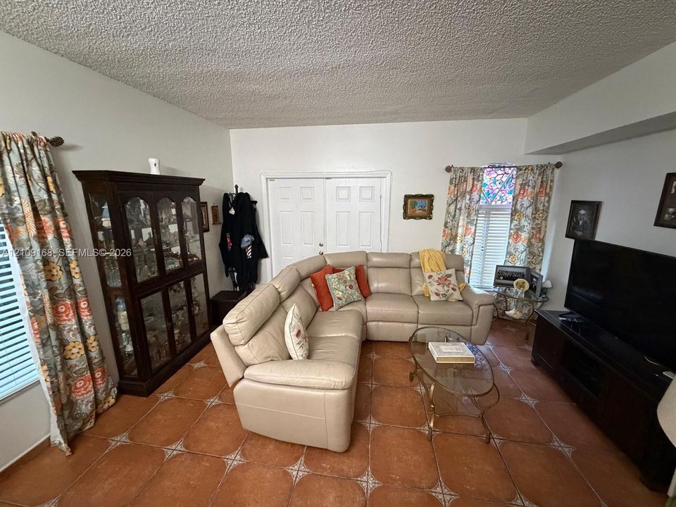 Ceramic tile flooring, white double doors, and a window accented with decorative stained glass