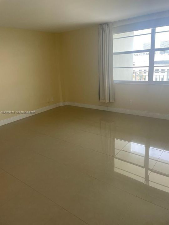 Interior space featuring polished tile flooring, neutral wall tones, and large horizontal-pane windows