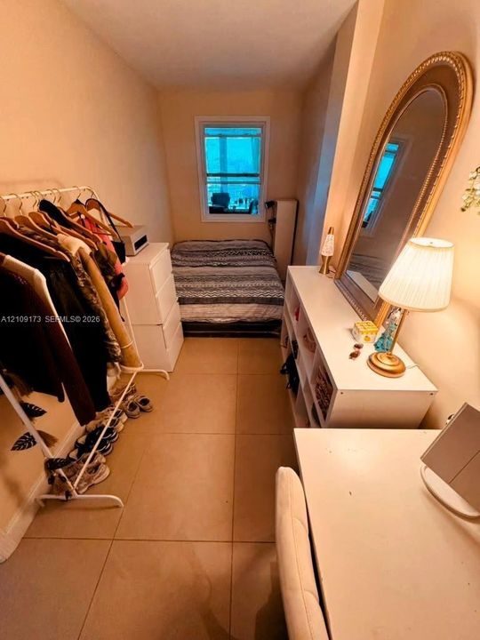 Room featuring large-format ceramic tile flooring and a single-pane window