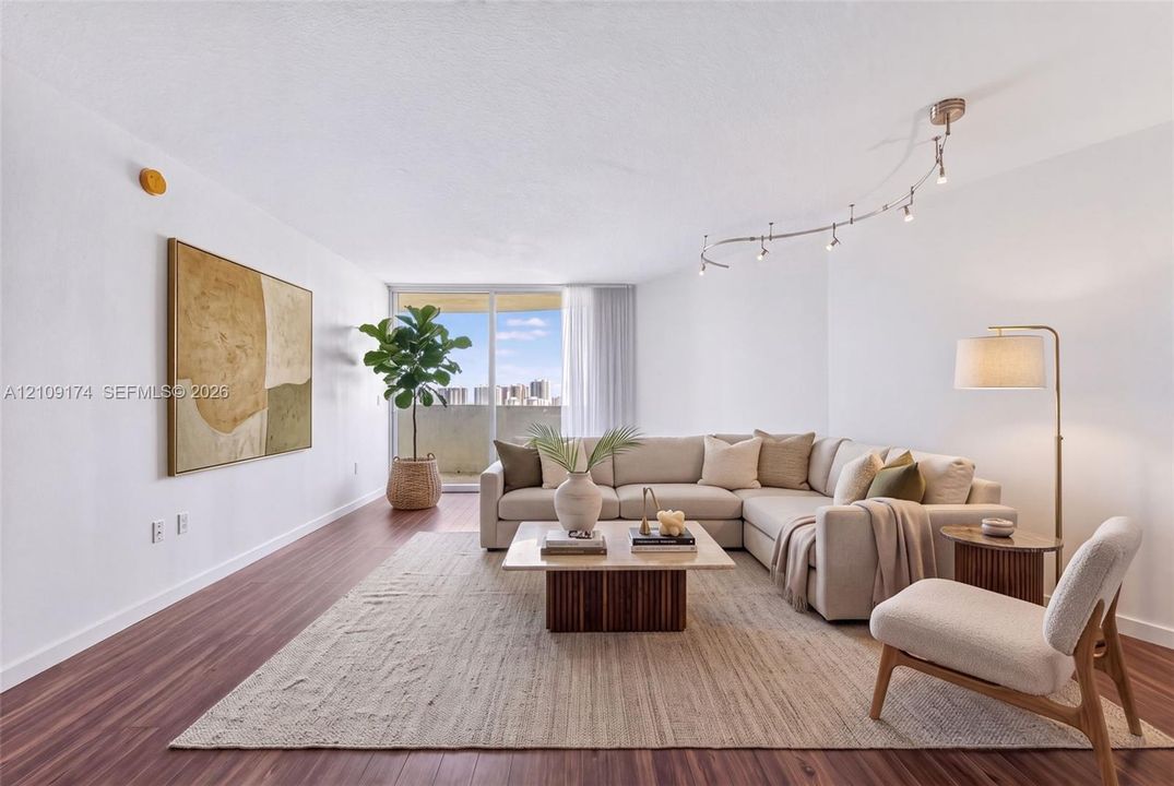 Open living space featuring wood-finish flooring, adjustable track lighting, and expansive sliding glass doors providing outdoor access