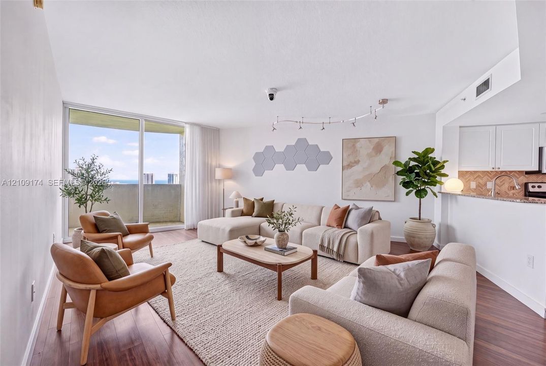 Living area featuring wood-finish flooring, floor-to-ceiling glass sliding doors, track lighting, and a breakfast bar with a herringbone-patterned tile backsplash
