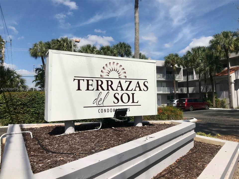 Terrazas del Sol monument signage featuring a raised concrete planter base with mulch landscaping