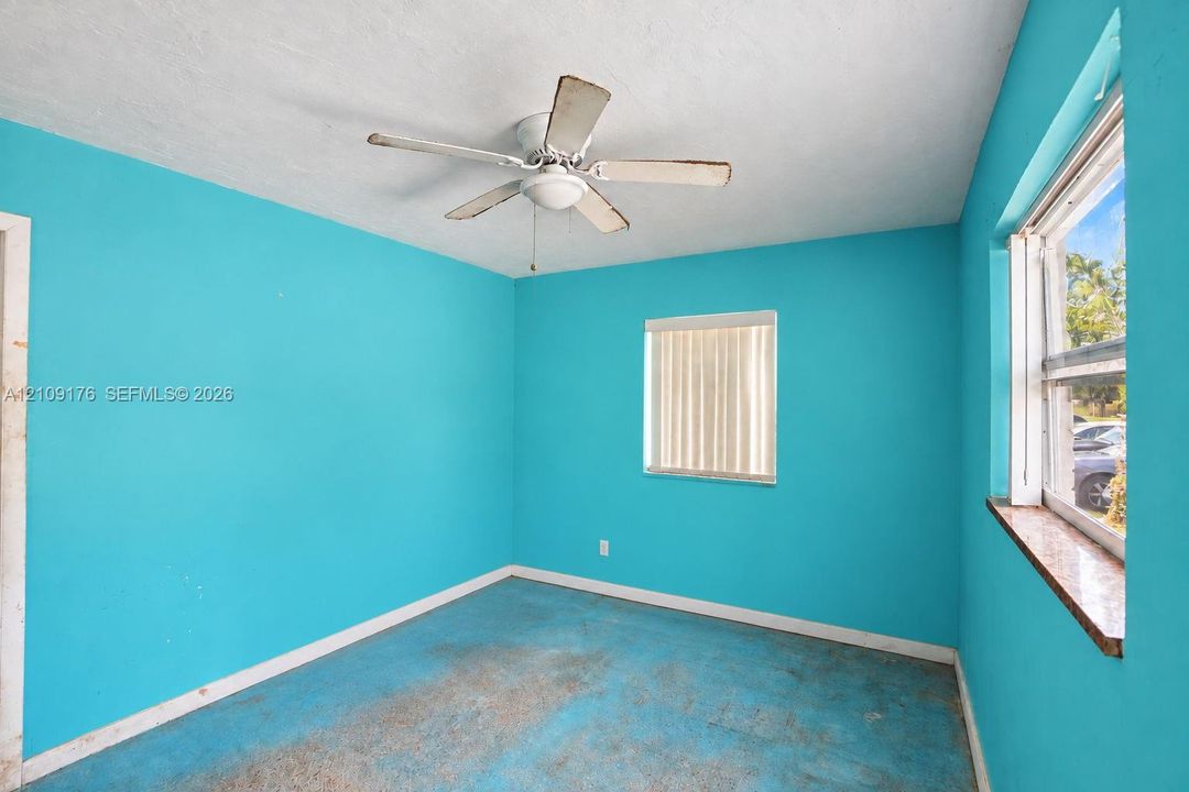 Room featuring dual windows, a ceiling fan with light fixture, and a stone-finish window sill