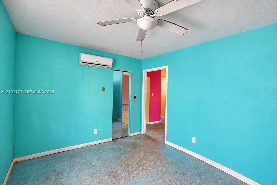 Wall-mounted ductless air conditioning unit, ceiling fan with integrated lighting, and mirrored closet doors