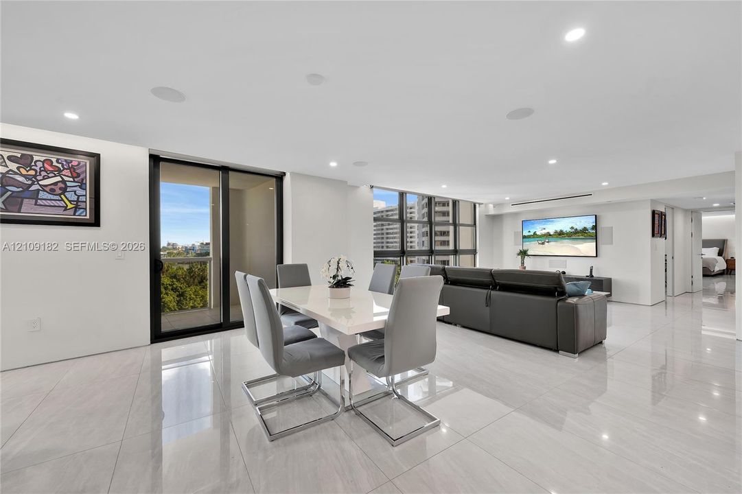 Open-concept interior featuring large-format tile flooring, floor-to-ceiling glass windows, recessed ceiling lighting, and sliding glass doors