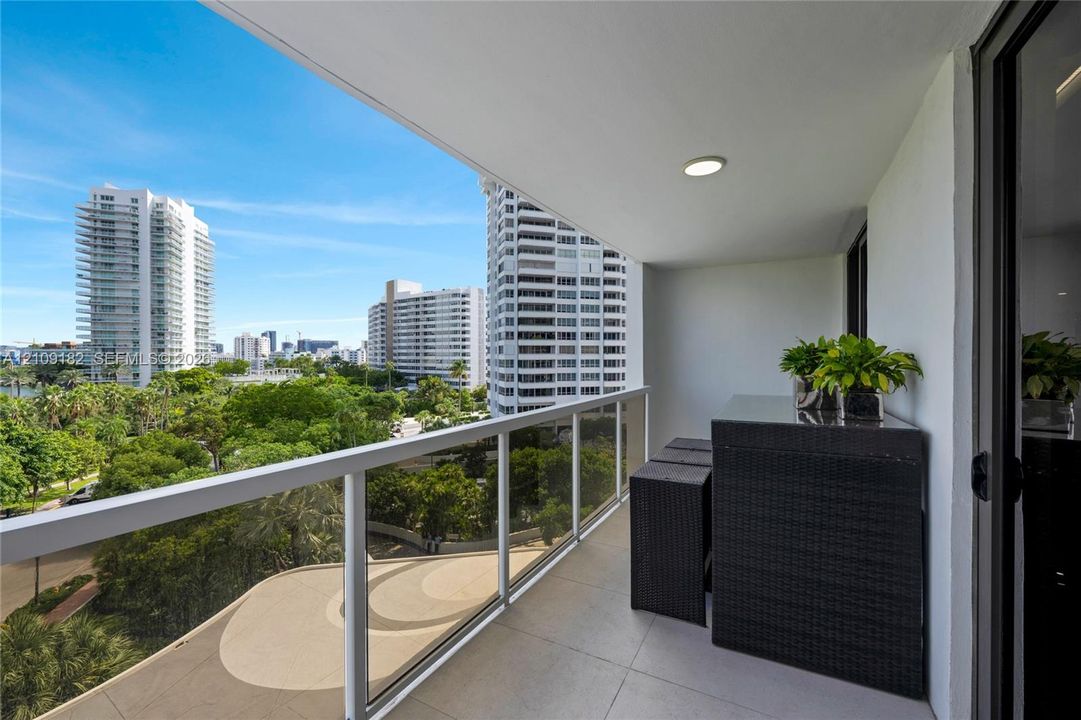 Private balcony featuring large-format tile flooring, recessed lighting, and a protective glass and metal railing system