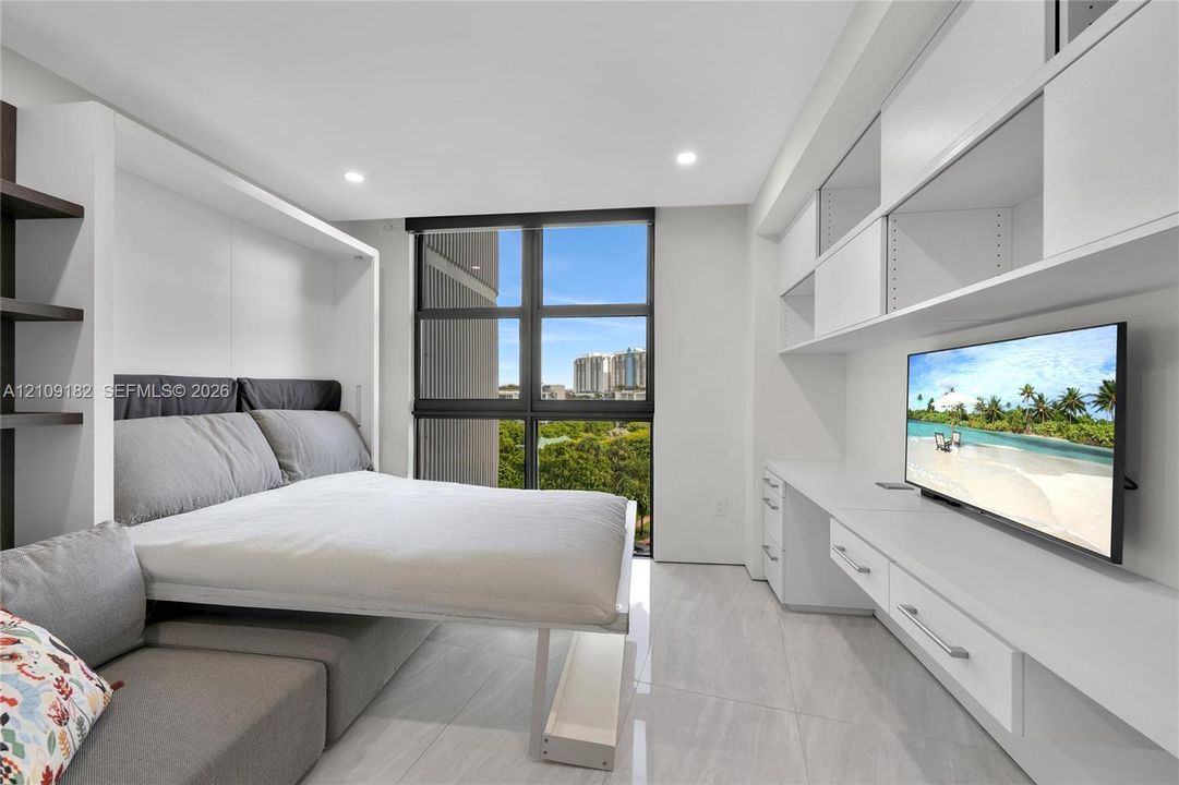 Built-in white cabinetry with integrated desk space and shelving, high-gloss floor tile, and large-format windows with structural mullions