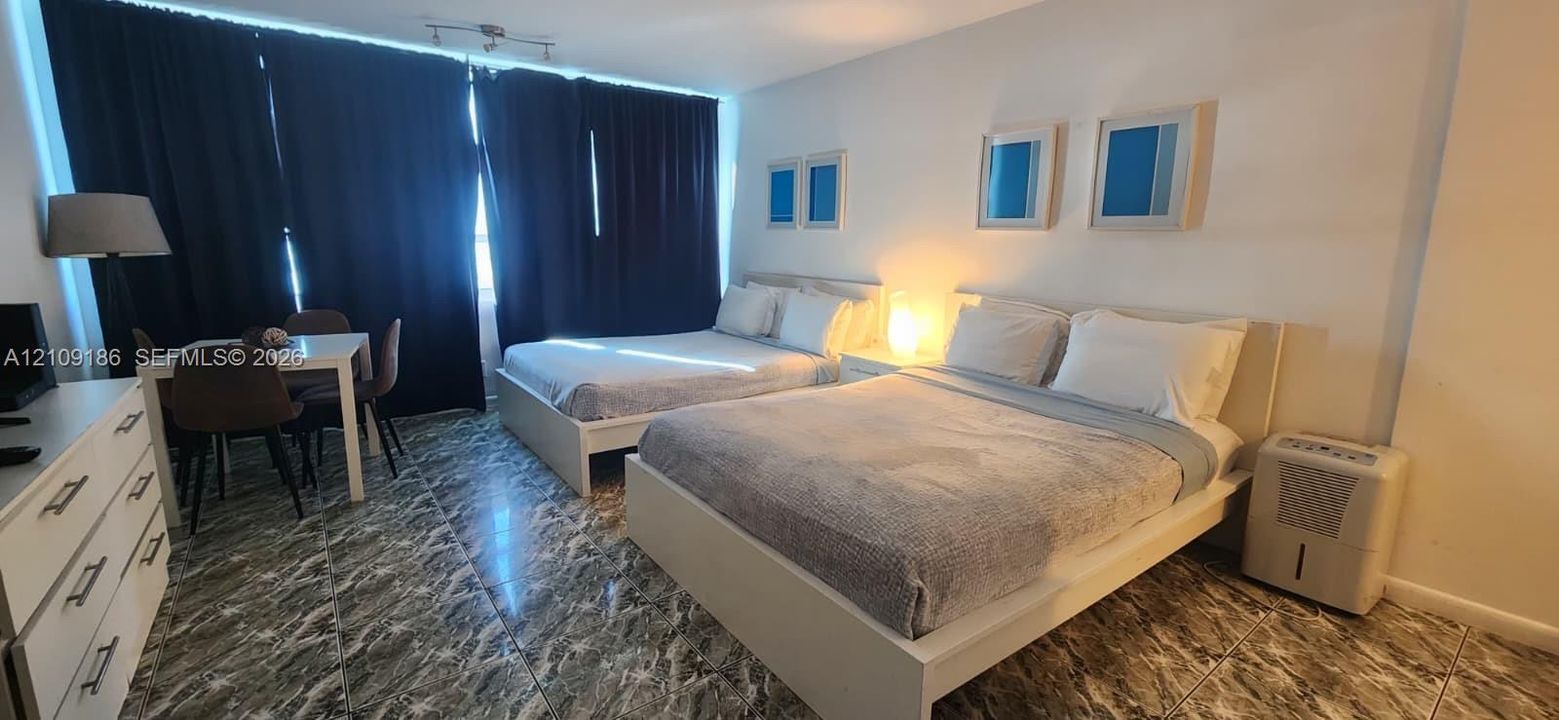 Spacious interior featuring patterned tile flooring and ceiling-mounted track lighting