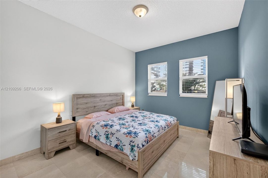 Neutral-toned tile flooring, dual-tone wall finish, and two double-hung windows with integrated blinds