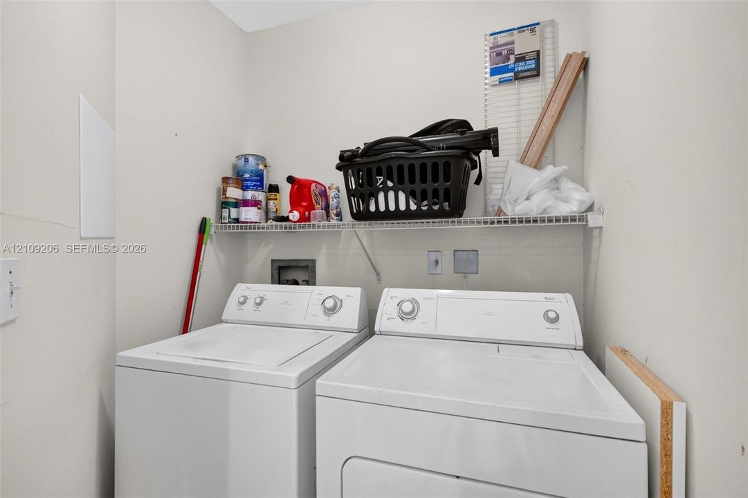 Dedicated laundry area featuring a white wire shelving unit and hookups for appliances