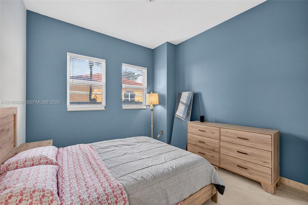 Spacious room featuring dual-pane windows, neutral-toned tile flooring, and a crisp, matte-finish wall treatment