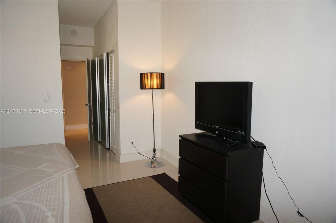 Glossy tile flooring and bi-fold closet doors with white frames