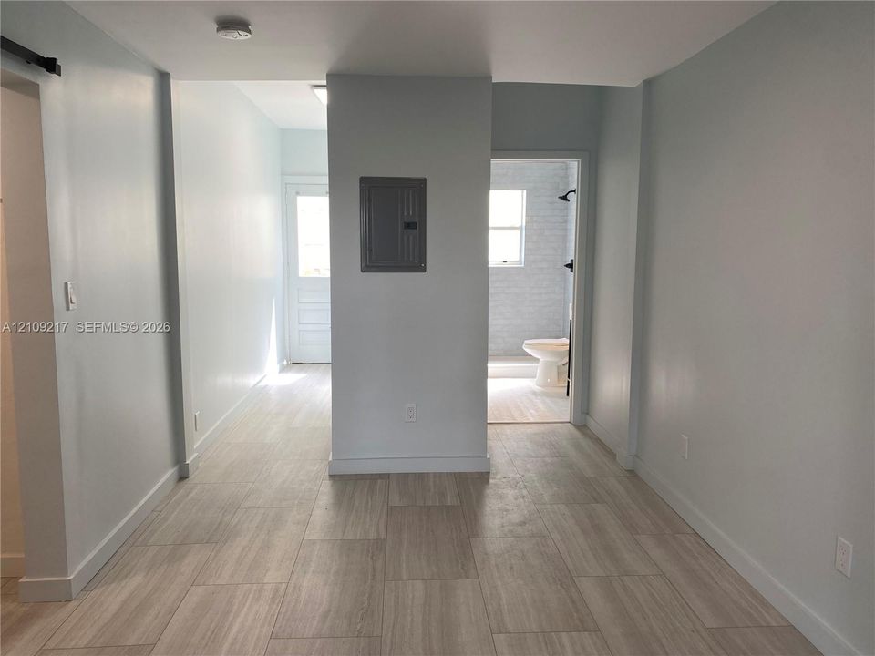 Neutral-toned tile flooring, recessed ceiling lighting, and a multi-lite glass panel exterior door