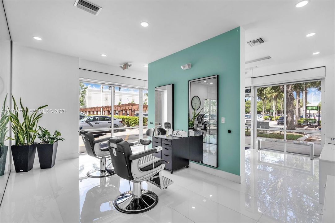 Polished tile flooring, recessed ceiling lighting, full-length wall mirrors, and expansive floor-to-ceiling windows