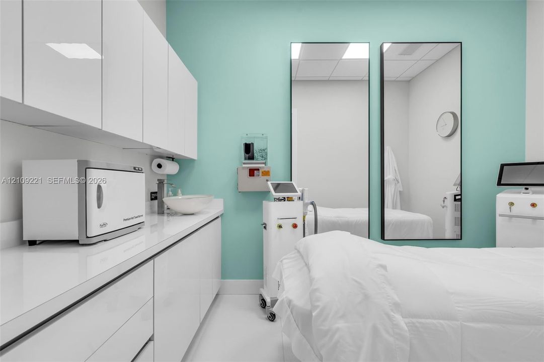 Modern space featuring white high-gloss cabinetry, integrated solid-surface countertop, vessel sink with chrome faucet, and dual full-length mirrors with dark frames