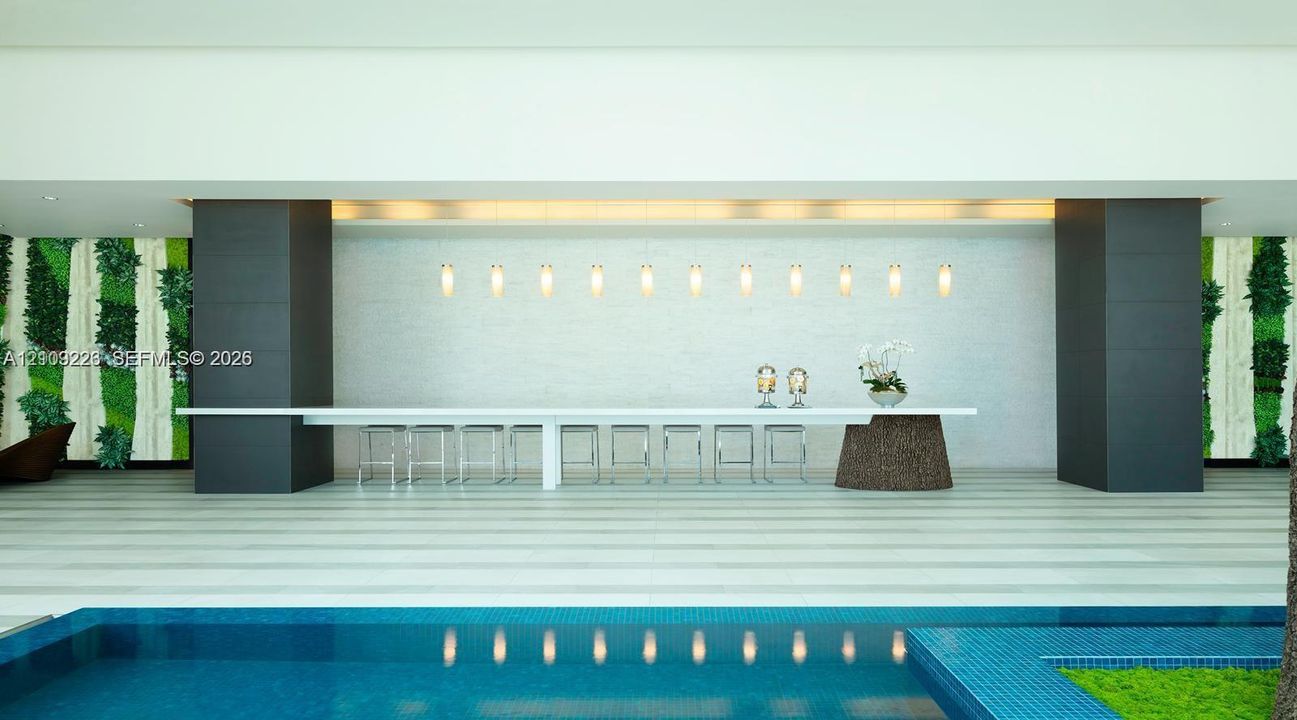 Custom long-format counter with a stone pedestal base, linear pendant lighting, textured feature wall, and integrated vertical greenery accents, overlooking a tiled swimming pool