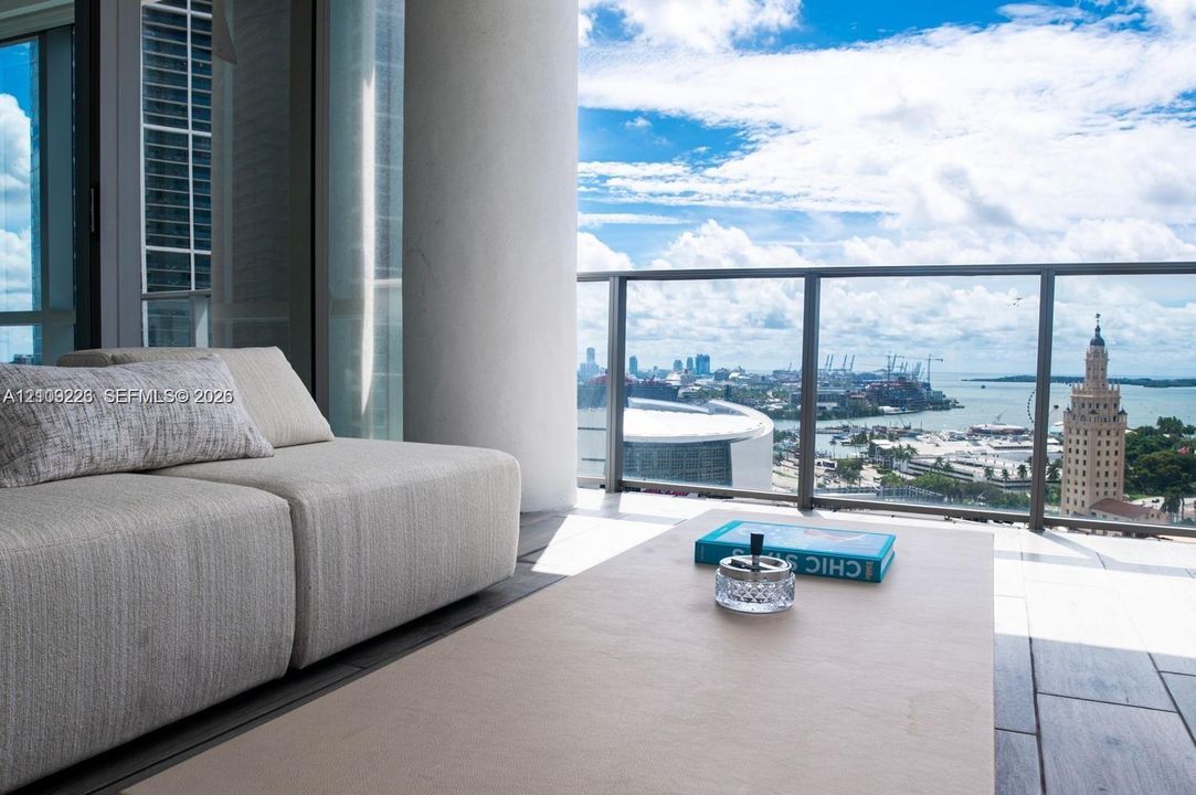 Private balcony featuring tile flooring and a glass-paneled railing