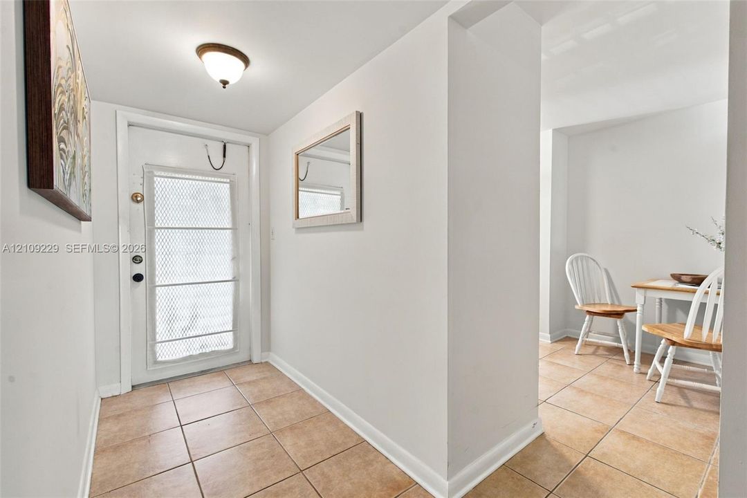 Entryway featuring ceramic tile flooring, a white exterior door with glass inlay, and a flush-mount ceiling fixture