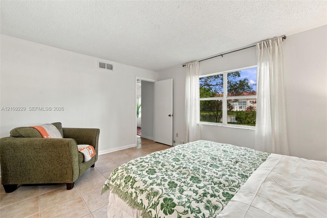 Neutral interior walls, large window with exterior exposure, and neutral stone-finish tile flooring