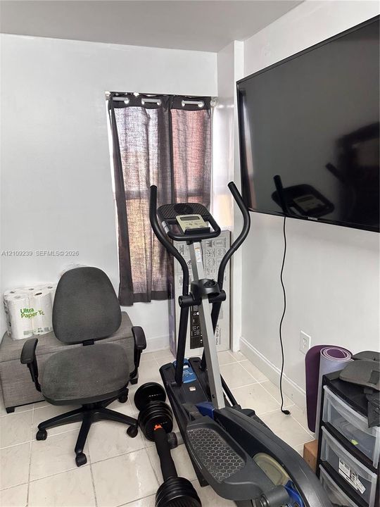 Room featuring tile flooring and a wall-mounted flat-screen television