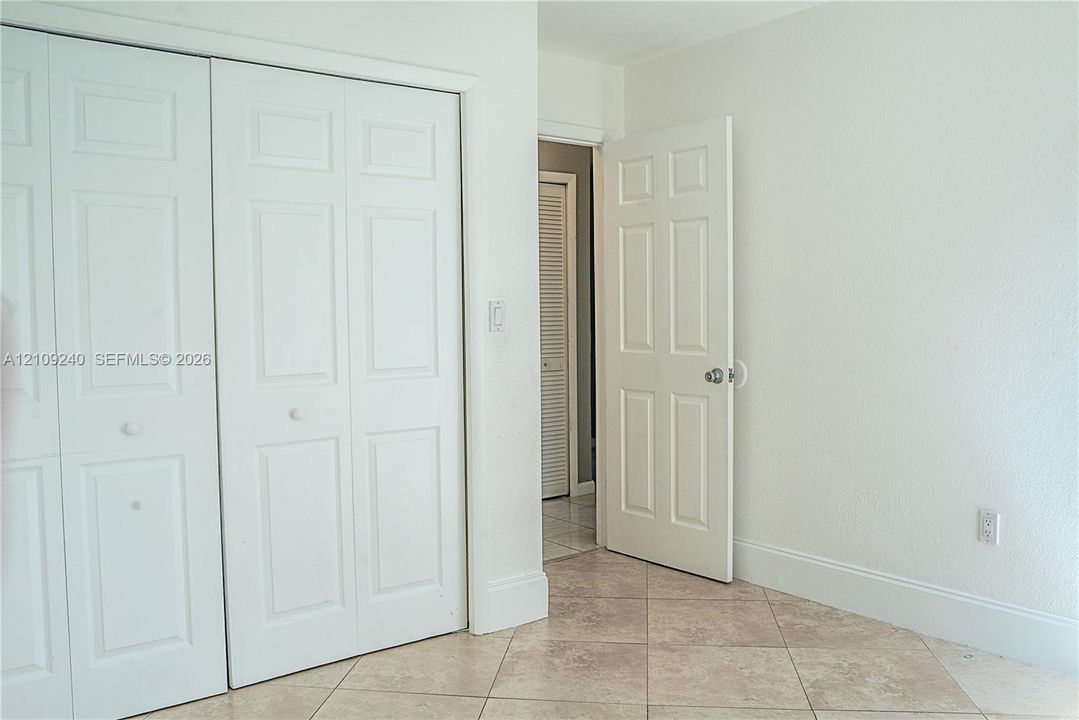 Interior room featuring ceramic tile flooring, two-panel closet doors, and six-panel interior door