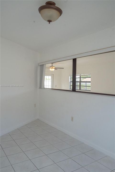 White ceramic tile flooring, semi-flush mount dome ceiling fixture, and interior rectangular wall cutout