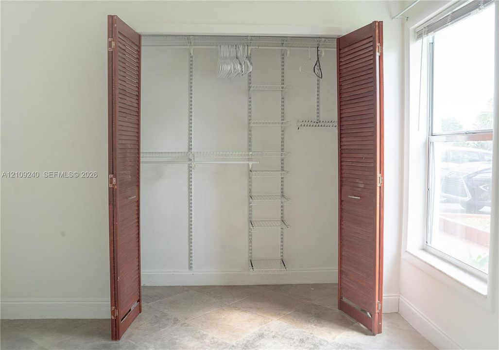 Closet featuring bi-fold louvered wood doors and a white wire shelving system