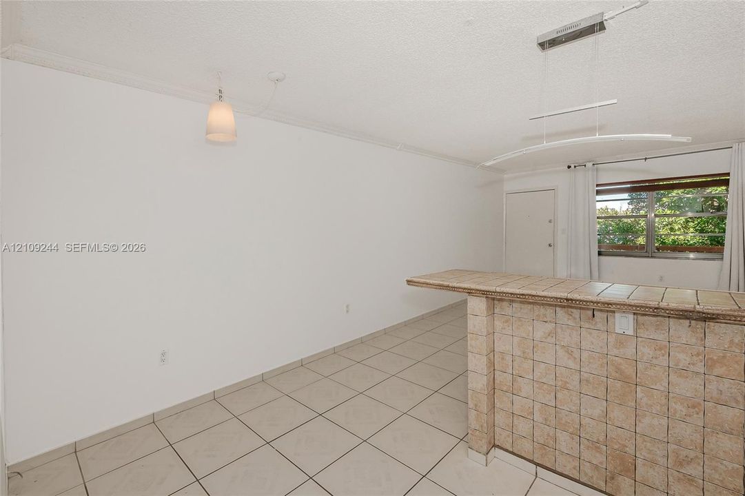 Ceramic tile flooring, built-in tiled breakfast bar, contemporary pendant lighting, and horizontal sliding windows
