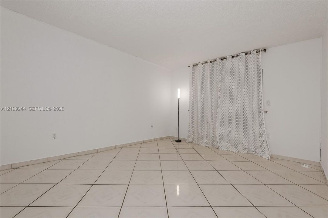 Room featuring neutral wall finishes and large-format ceramic tile flooring installed in a diagonal pattern