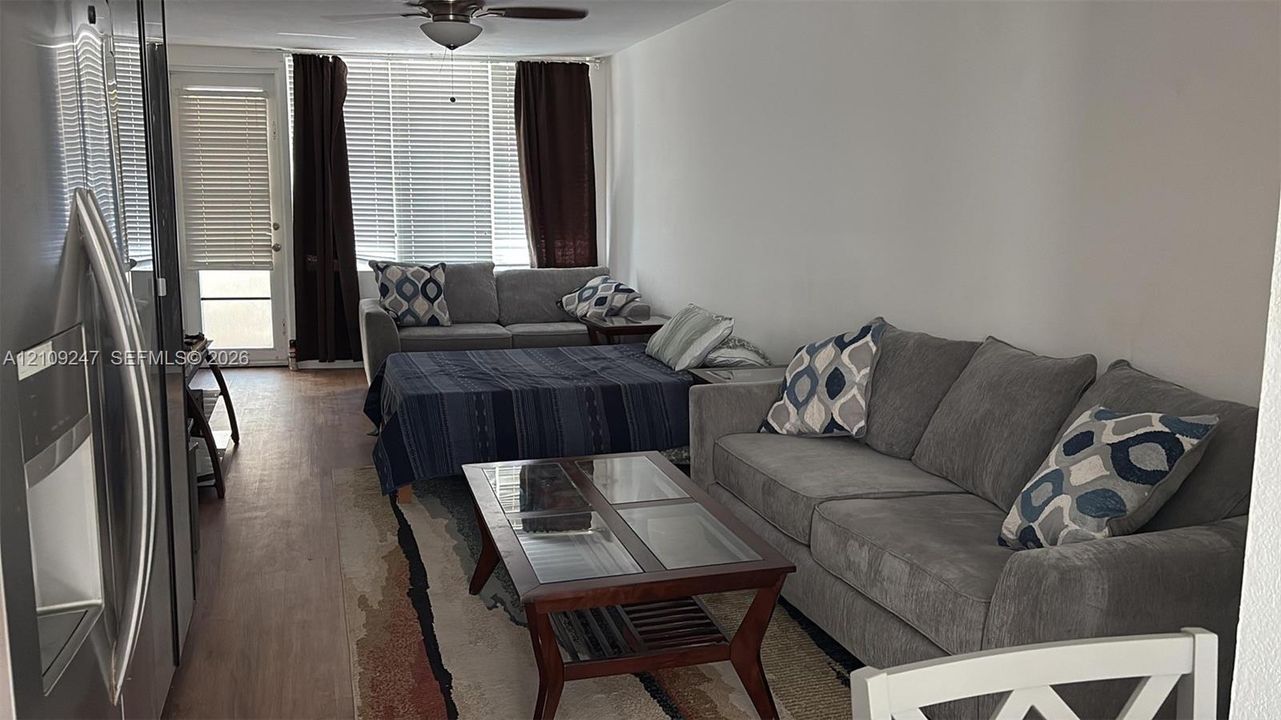 Wood-finish flooring, ceiling fan, and access to exterior door with glass insert