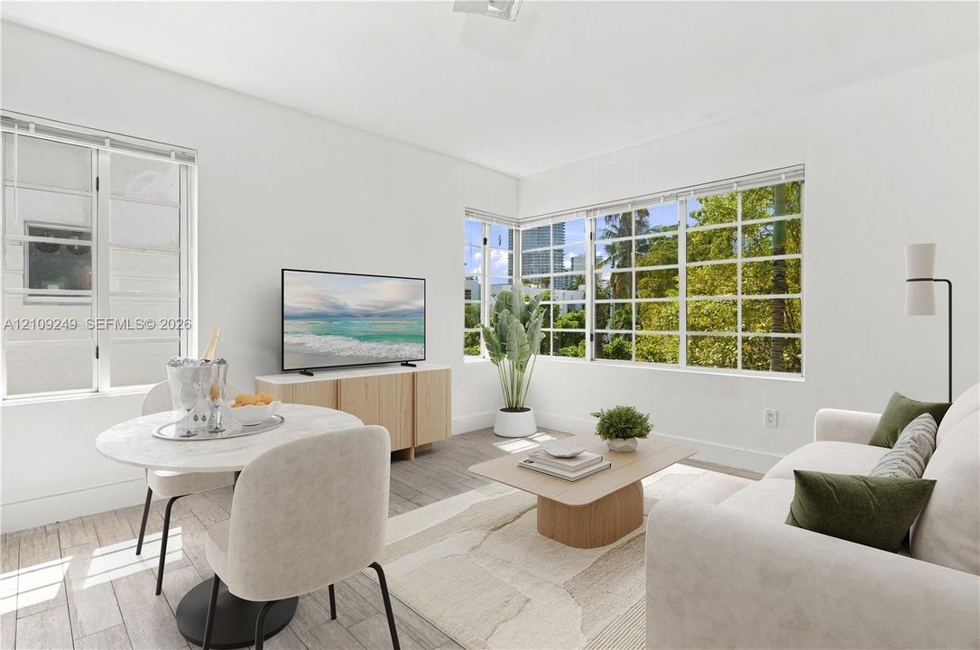 Living area featuring large multi-pane windows, neutral wall finishes, and wood-finish flooring