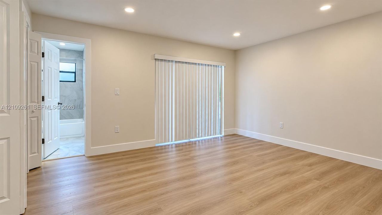 Interior space featuring wood-finish flooring, recessed lighting, and vertical window blinds