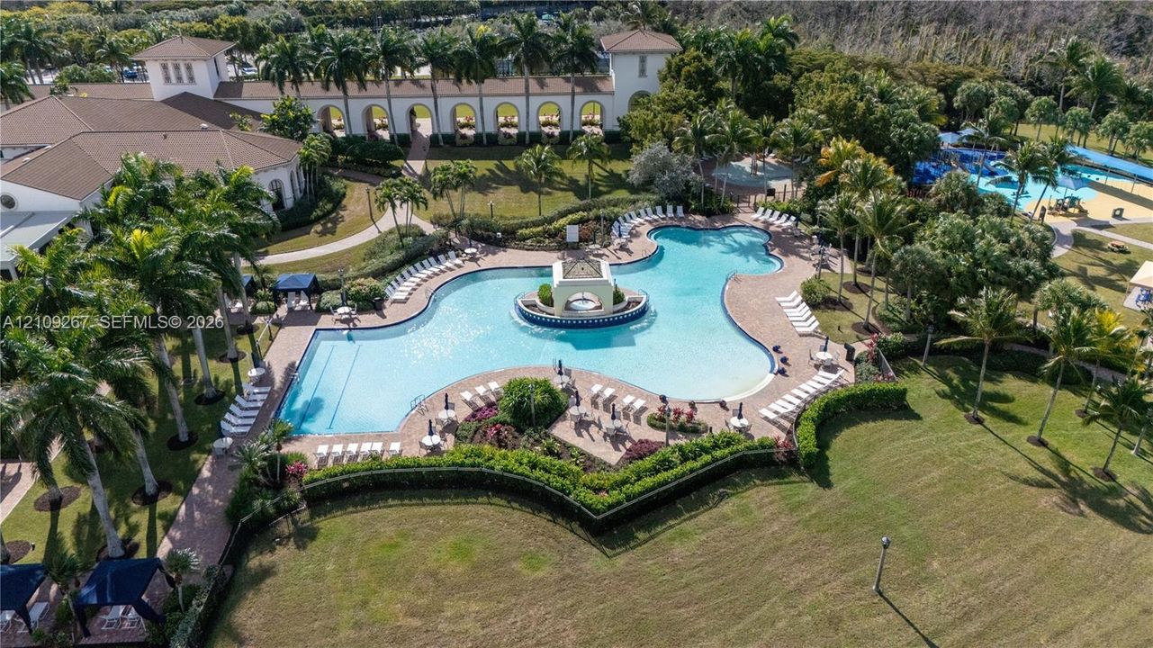 Resort-Style Zero-Entry Pool with Integrated Spa and Lazy River Feature, Surrounded by Mature Landscaping and Manicured Grounds