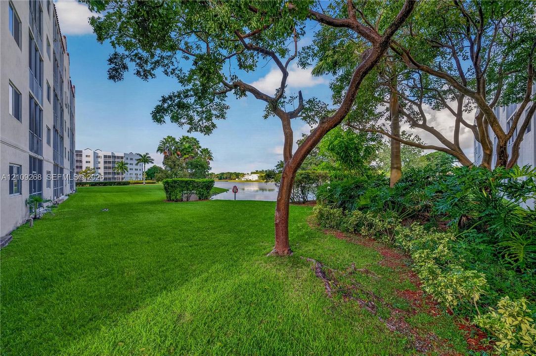 Extensive lawn area featuring mature trees, lush perimeter landscaping, and waterfront grounds