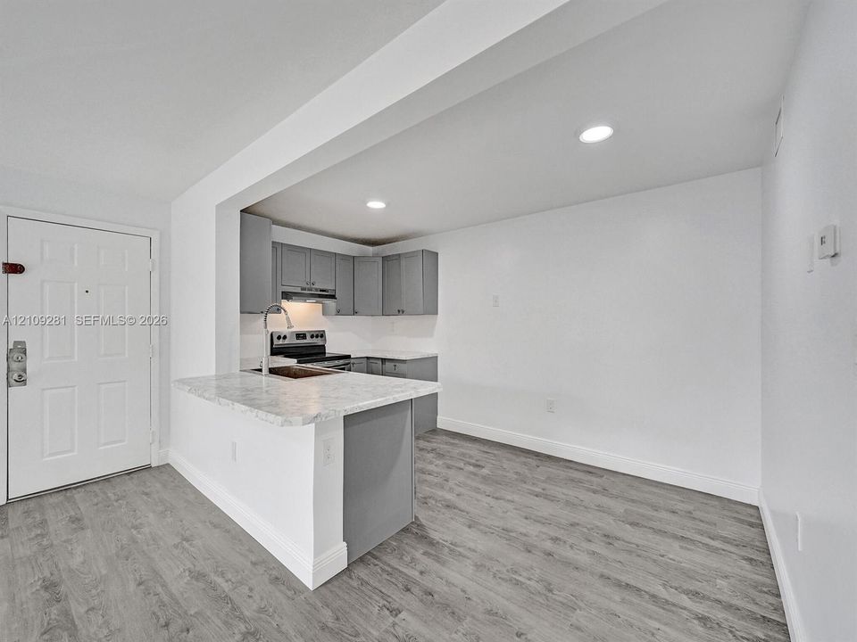 Kitchen featuring light-toned cabinetry, stone-finish countertops, recessed lighting, and wood-finish flooring