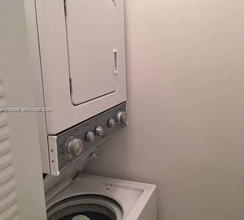 Stacked white laundry unit featuring a top-loading washer, front-loading dryer, and tactile control knobs