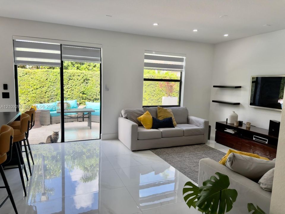 High-gloss tile flooring, floor-to-ceiling sliding glass doors, recessed lighting, and built-in wall-mounted shelving