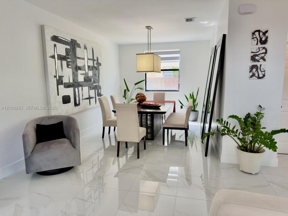 Neutral-toned interior space featuring polished large-format tile flooring and a suspended rectangular pendant light fixture