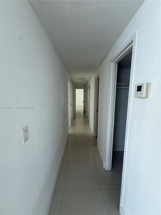 Neutral-toned tile flooring, flush-mount ceiling lighting, and multiple interior door openings