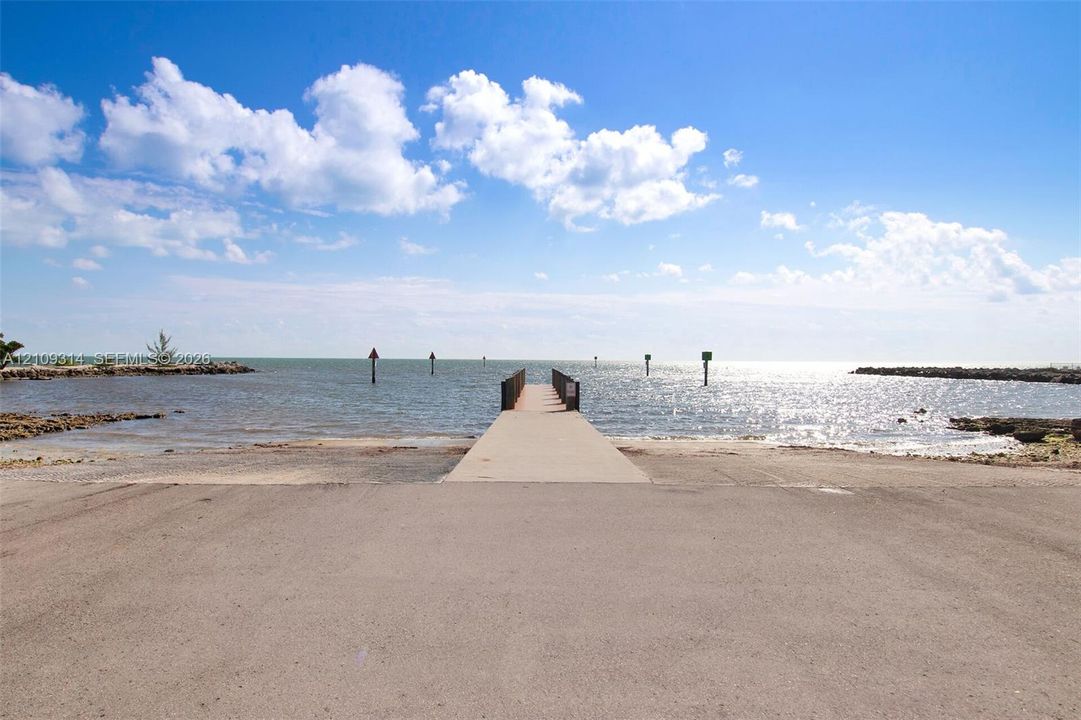 Concrete boat ramp featuring a central pier, rocky shoreline, and open water access