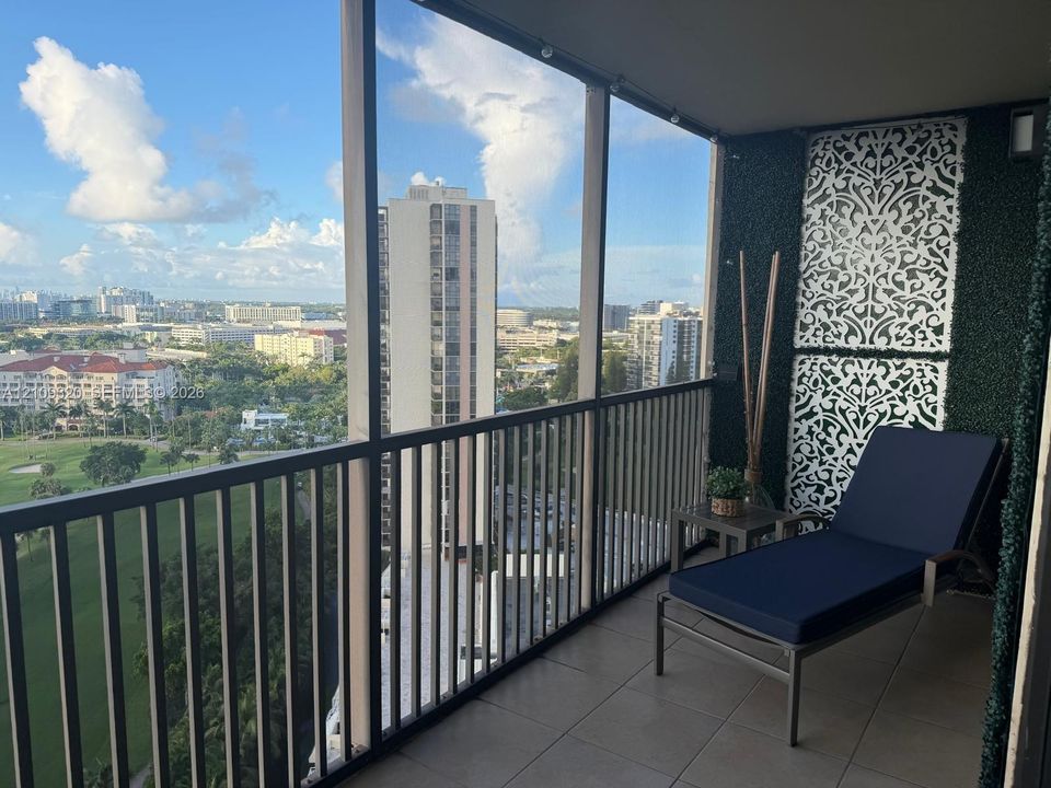 Screened balcony featuring tile flooring, metal railings, and decorative laser-cut wall panels